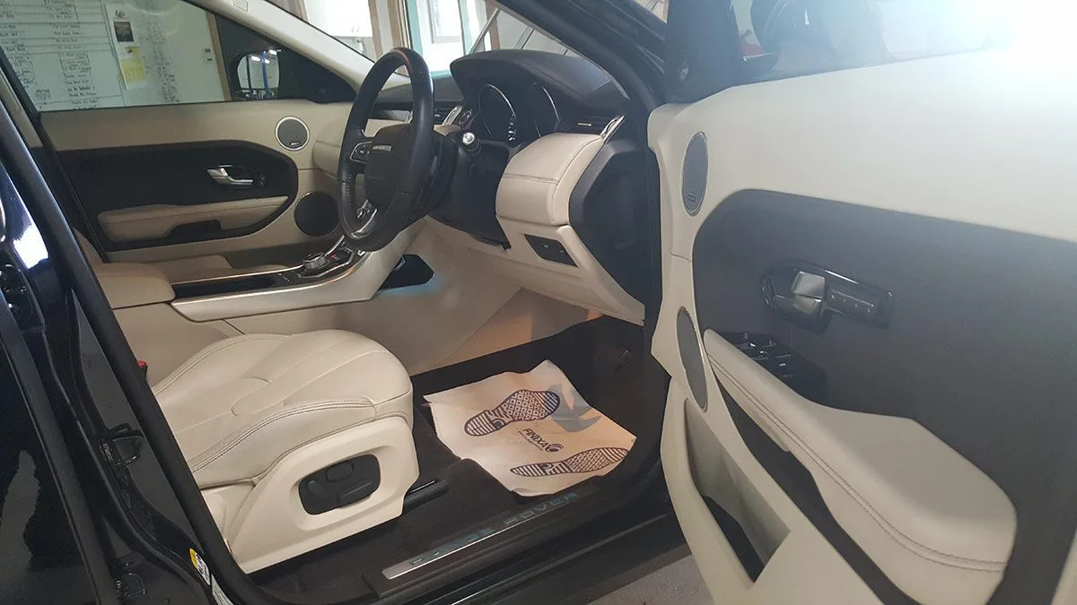 Cream leather front seats in a dark cabin after interior protection