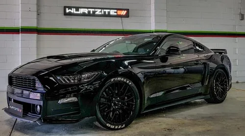 Black widebody Ford Mustang on Pirelli tyres under the Wurtzite sign