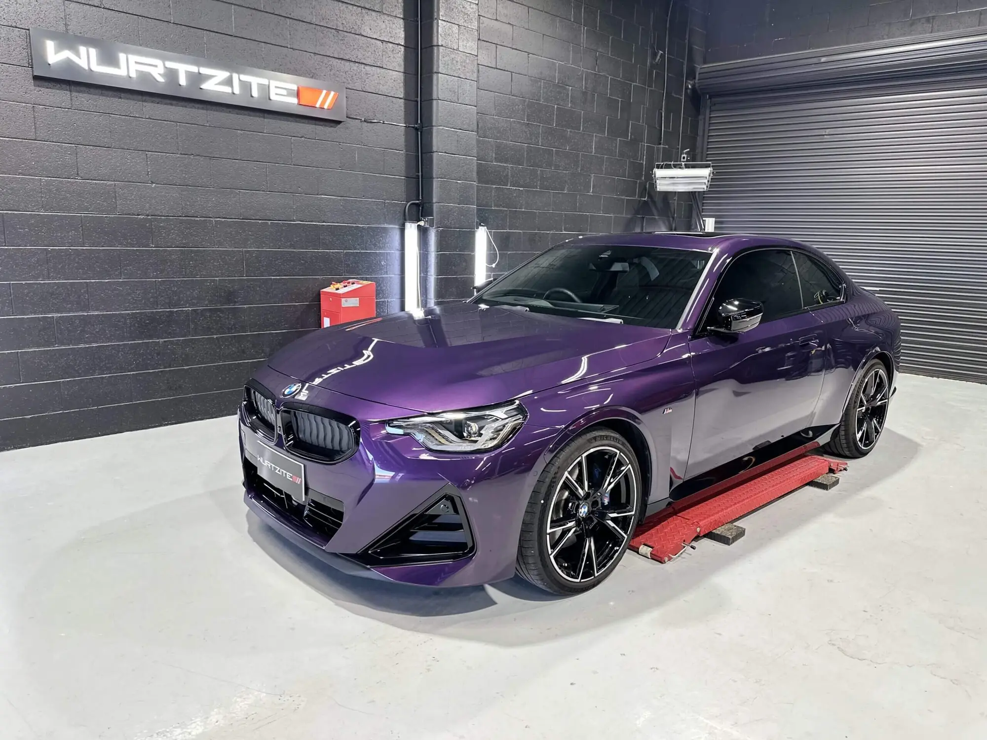 Purple BMW 2 Series on the ramp under the Wurtzite sign at Windsor Gardens
